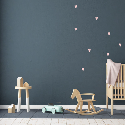 Schattige roze hartjes muurstickers in de babykamer op de muur geplakt. Sfeerafbeelding van de hartjes muursticker set van 25 stickertjes